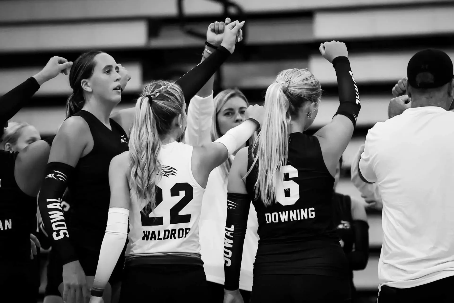 South Walton volleyball team huddling together on the court